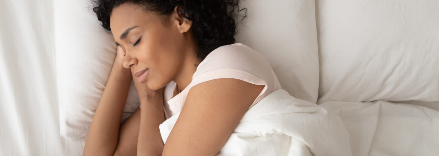 Woman asleep on comfortable bedding