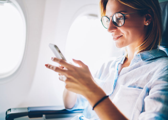 Woman using cellphone on plane