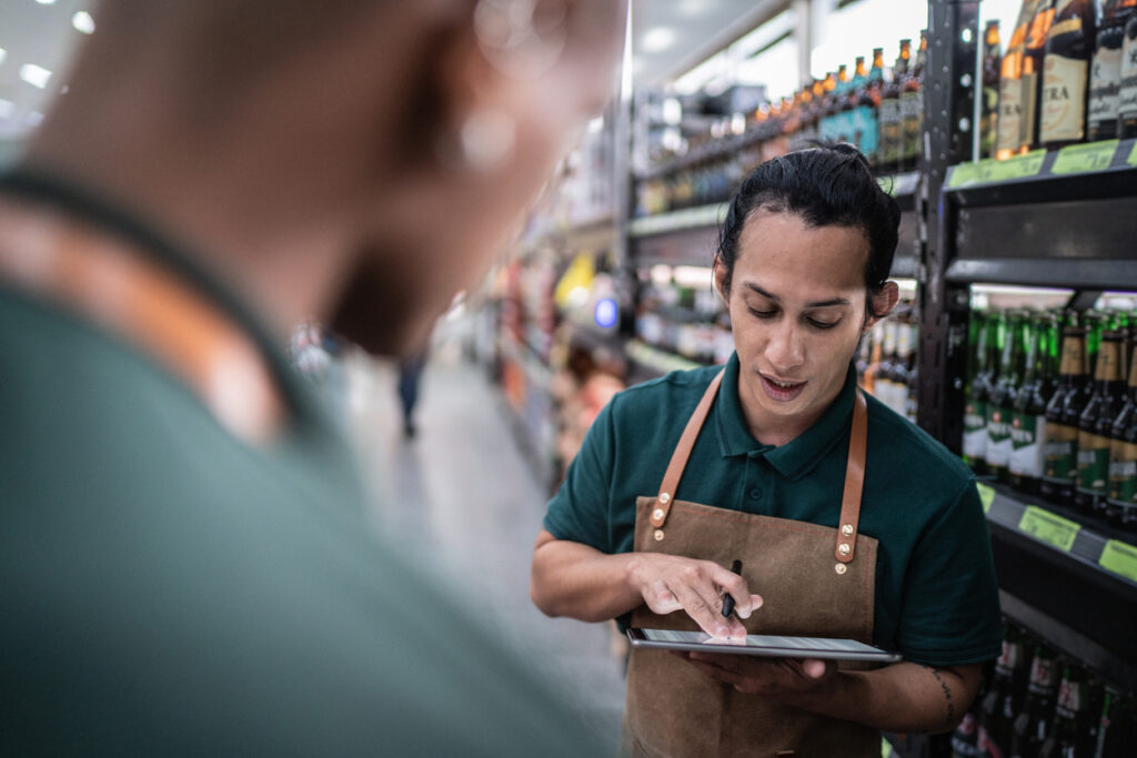 man using ipad in liquor store